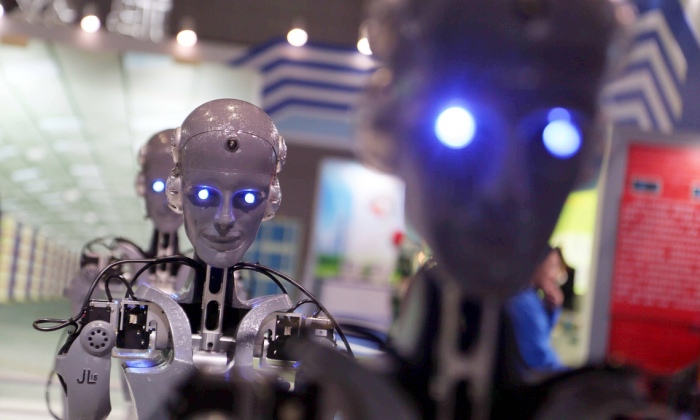 Работы, произведенные Shaanxi Jiuli Robot Manufacturing Co, отображаются на экране на технологической выставке в Шанхае. Фотограф: Imaginechina/Corbis